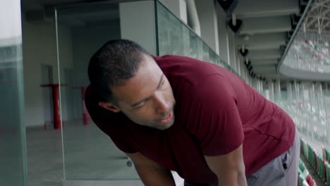 Retrato-De-Un-Hombre-Afroamericano-Caucásico-Entrenando-En-Una-Pista-De-Estadio-Vacía-Temprano-En-La-Mañana.-Toma-Tomada-Con-Lente-Anamórfica.